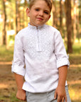 White linen boys’ vyshyvanka with white-steel embroidery and rolled-up sleeves