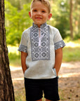 Light blue linen boys’ vyshyvanka with dark geometric embroidery and short sleeves