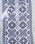 Close-up of dark geometric embroidery on a light blue boys’ emboidered shirt