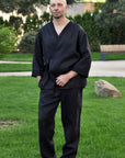 Man wearing a black linen kimono set with a wrap-style top and straight-leg pants