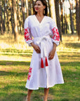 White embroidered linen dress with a feminine wrap silhouette and red floral motif