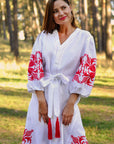 Women’s white embroidered linen dress with symbolic red ornament