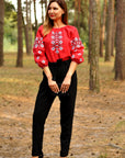 Women’s red embroidered blouse in natural linen styled with black trousers