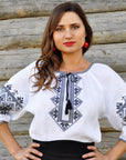 Women’s white embroidered blouse with black ornament and tassel ties