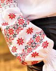 Festive white embroidered blouse styled with a black skirt and red accessories