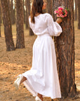 Women’s white ceremony dress with airy lace ornament on the sleeves
