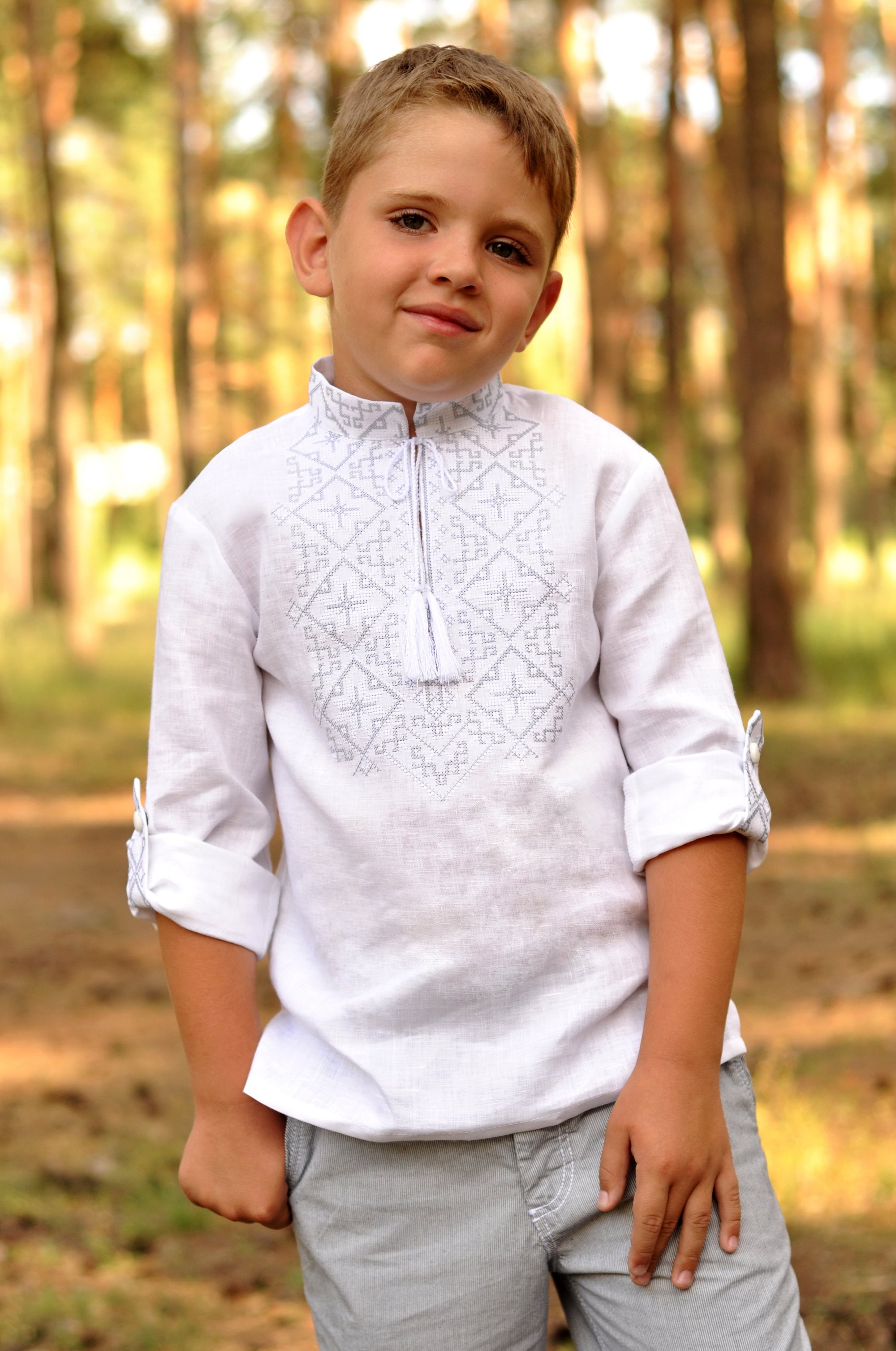 White linen boys’ vyshyvanka with white-steel embroidery and rolled-up sleeves