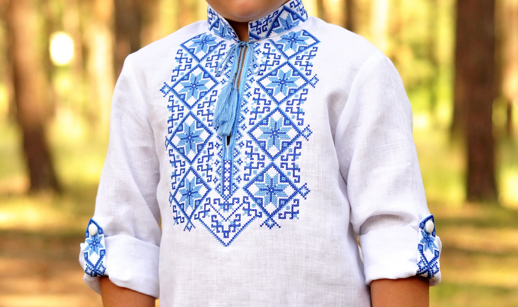 White boys’ Ukrainian-style embroidered shirt with long sleeves styled as 3/4 sleeves