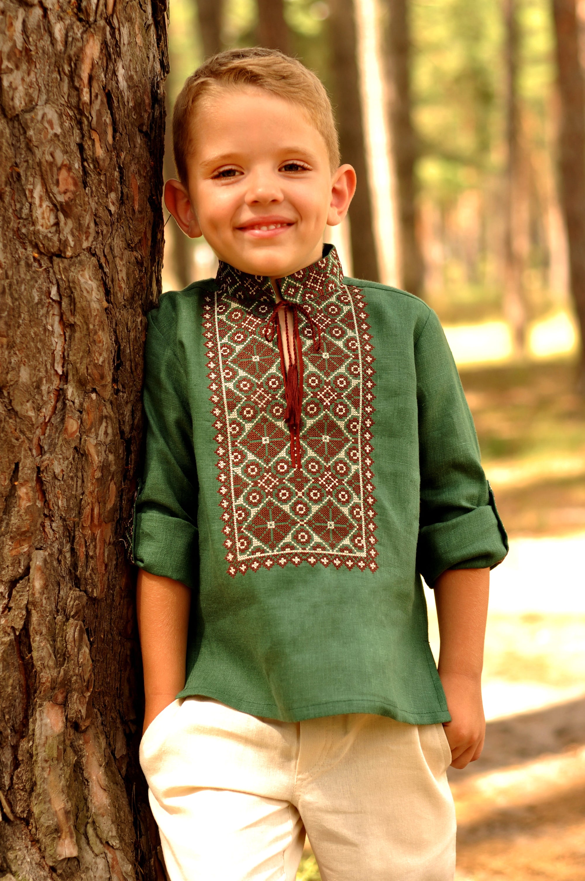 Green linen boys’ vyshyvanka with brown geometric embroidery and sleeves styled as 3/4