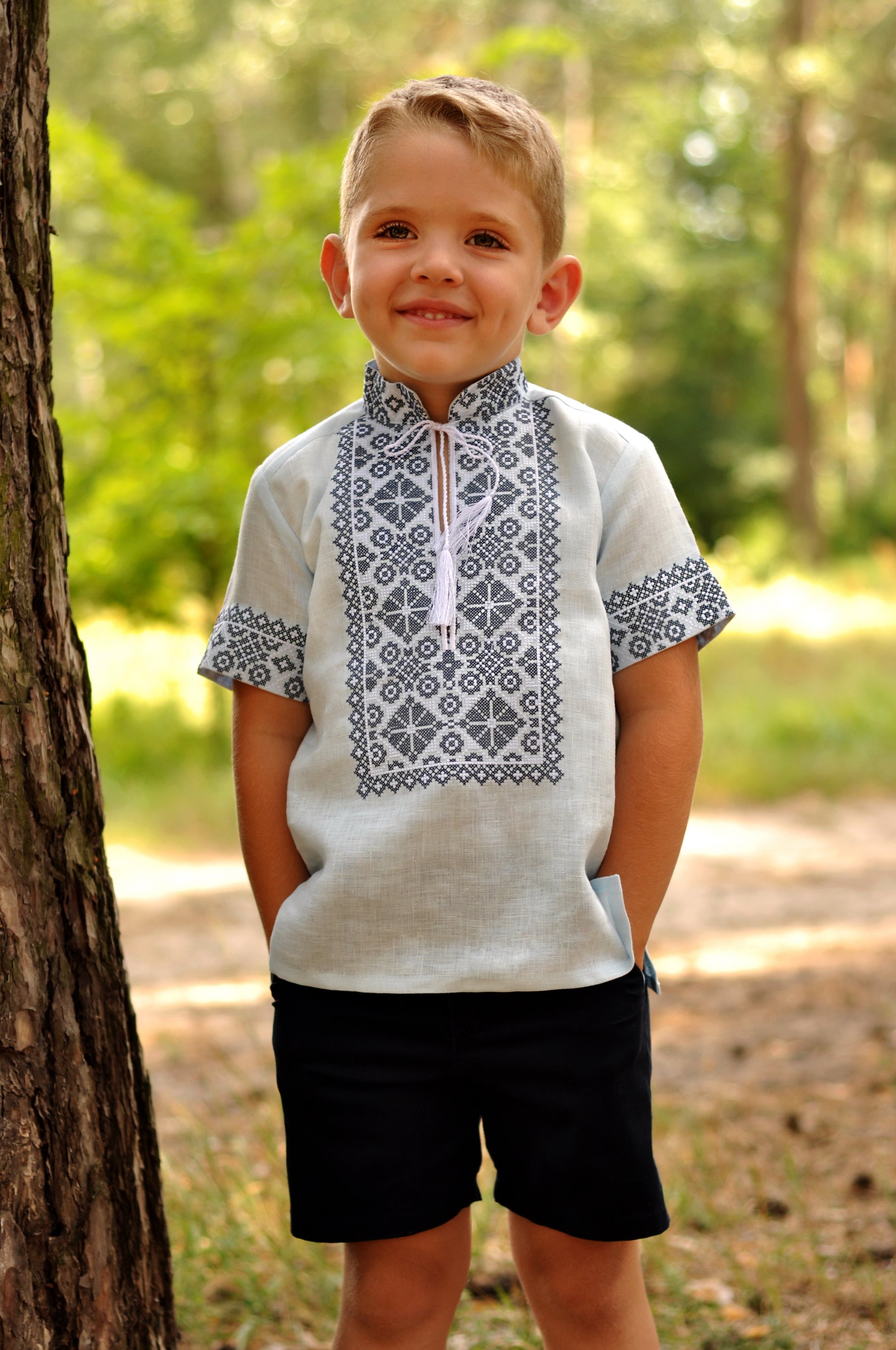 Light blue linen boys’ vyshyvanka with dark geometric embroidery and short sleeves