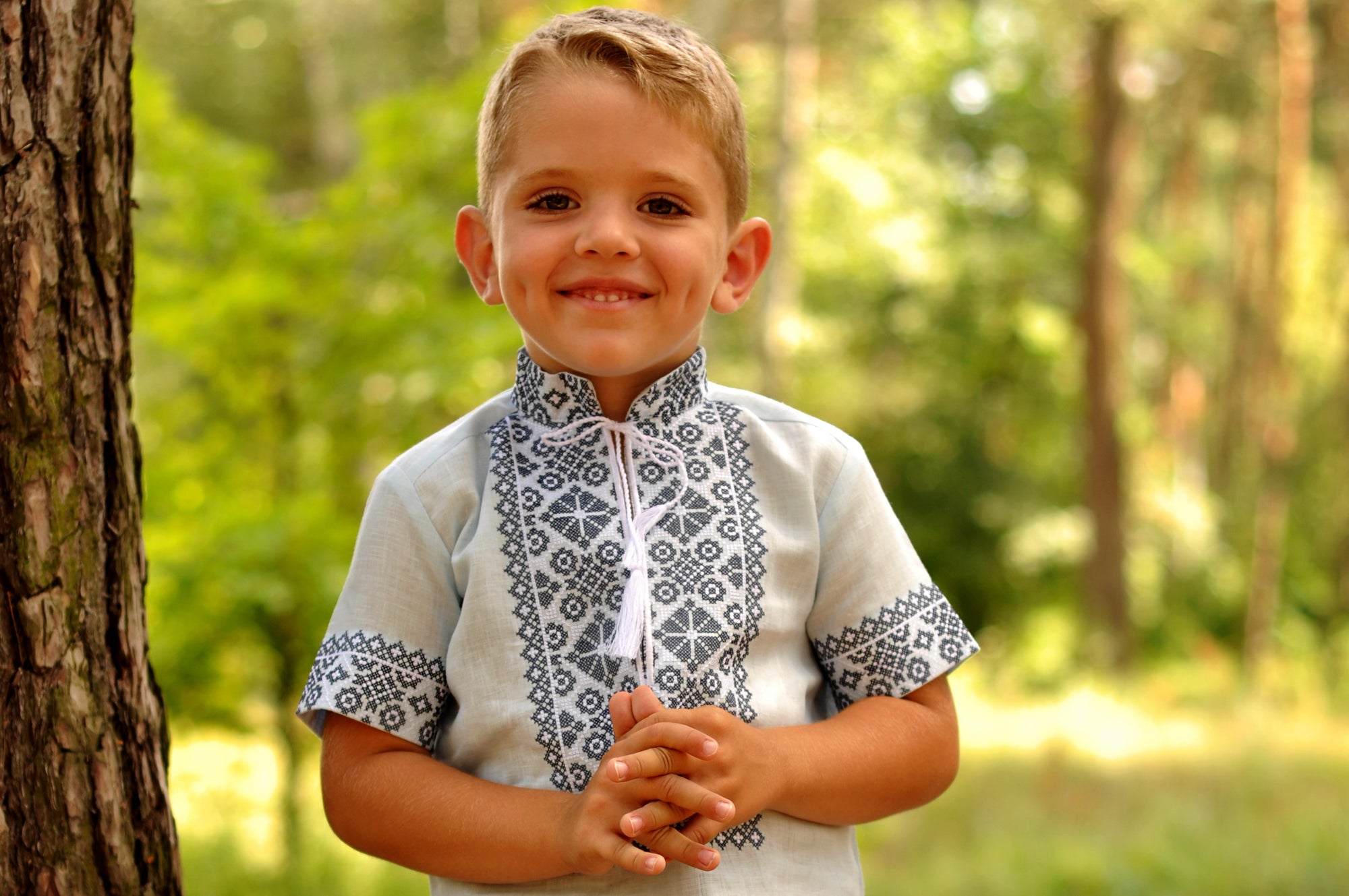 Close-up of dark geometric embroidery on a light blue boys’ vyshyvanka