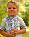 Close-up of dark geometric embroidery on a light blue boys’ vyshyvanka