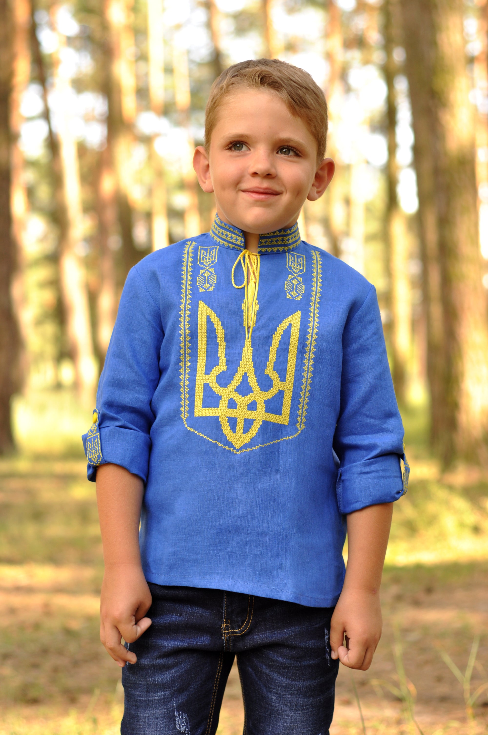 Blue linen boys’ vyshyvanka with yellow Trident embroidery and sleeves styled as 3/4