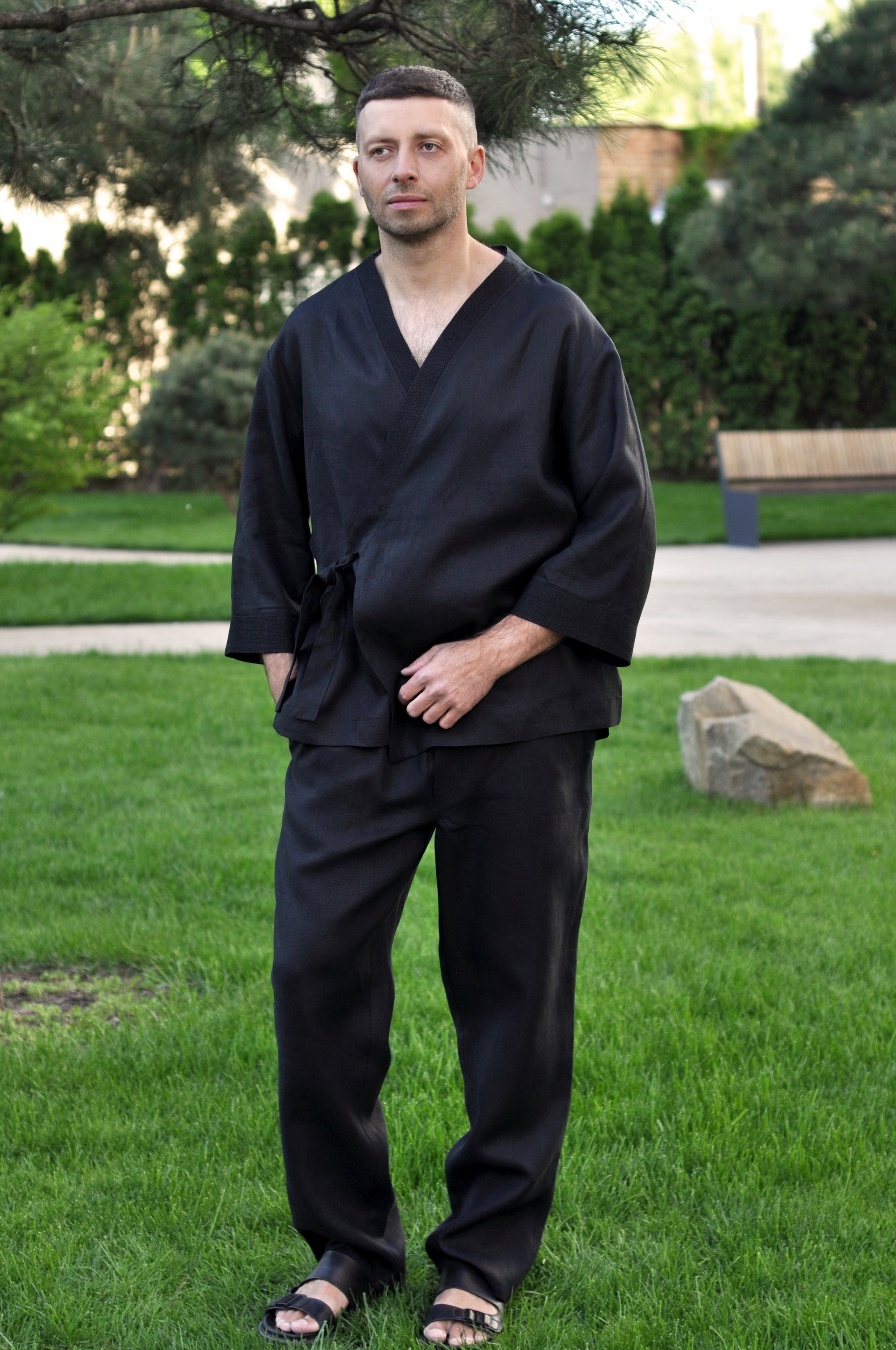 Man wearing a black linen kimono set with a wrap-style top and straight-leg pants
