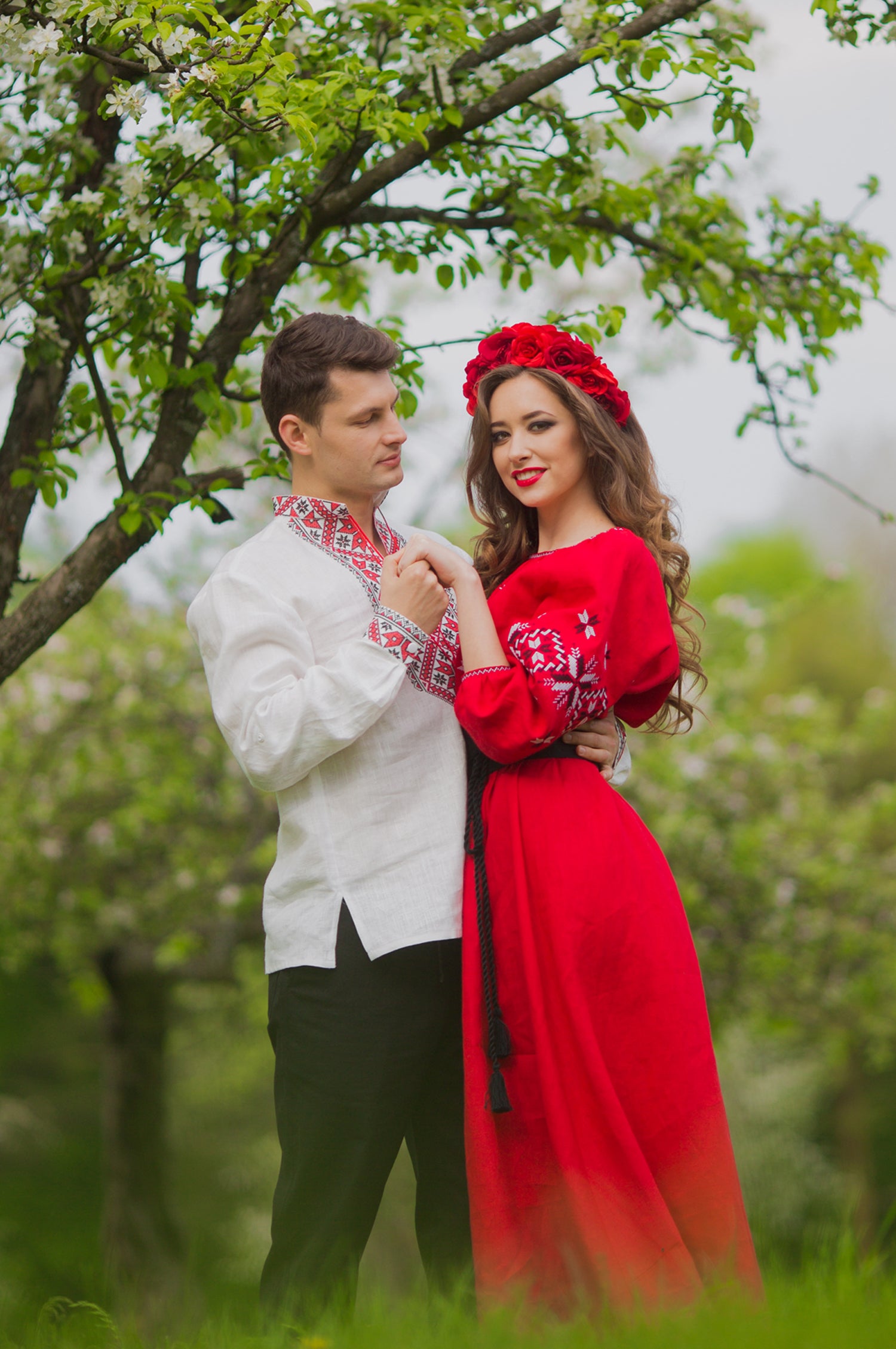 Family look set with men’s white embroidered shirt and women’s red embroidered dress with geometric ornament
