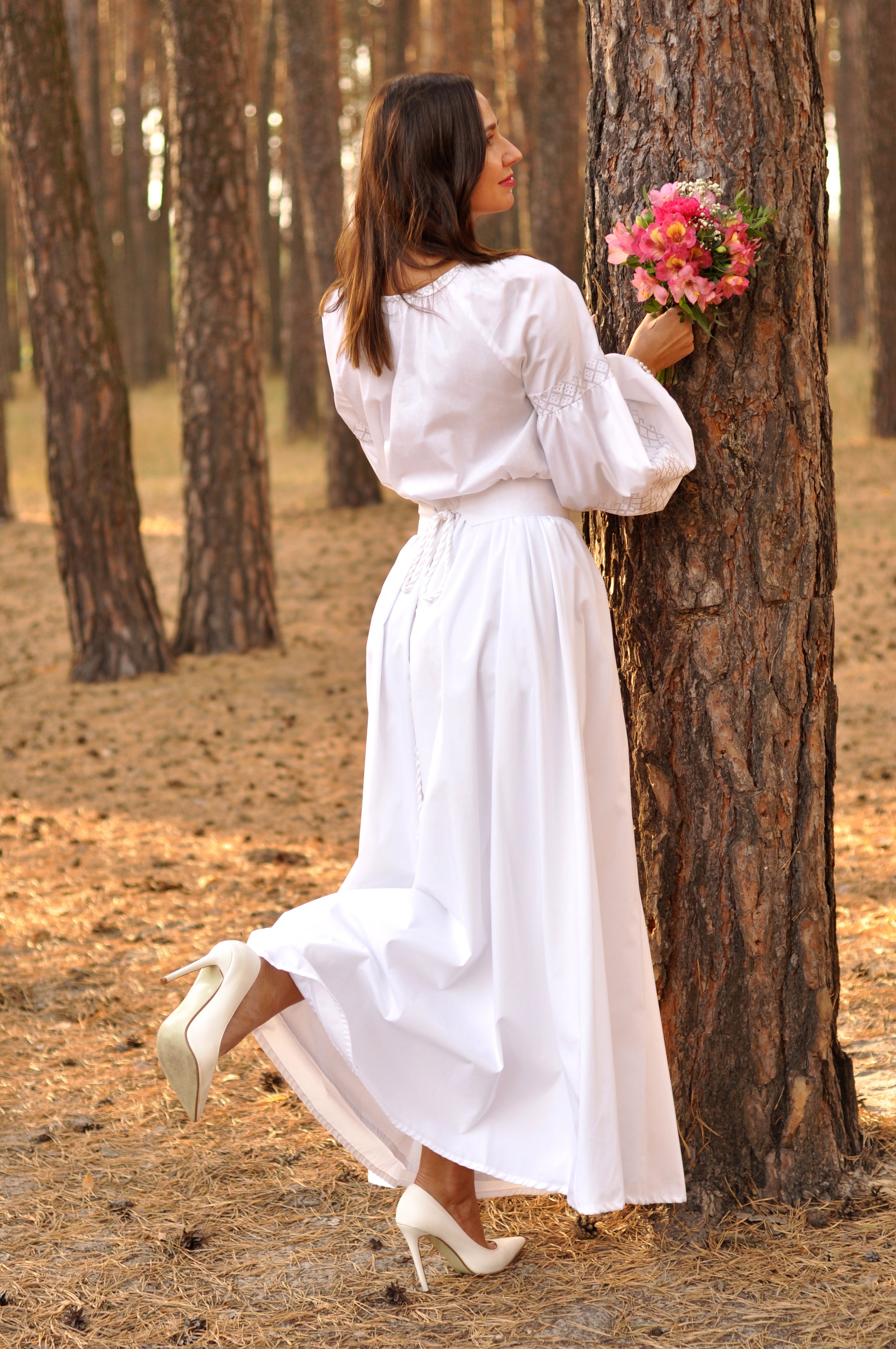 Women’s white ceremony dress with airy lace ornament on the sleeves