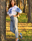 Women’s white embroidered blouse with 3/4 sleeves and dimensional blue ornament